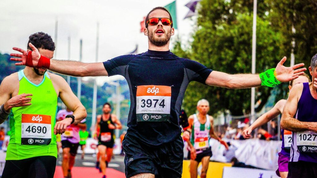 Corredor avanzando rápidamente, con enfoque y determinación durante una carrera al aire libre.